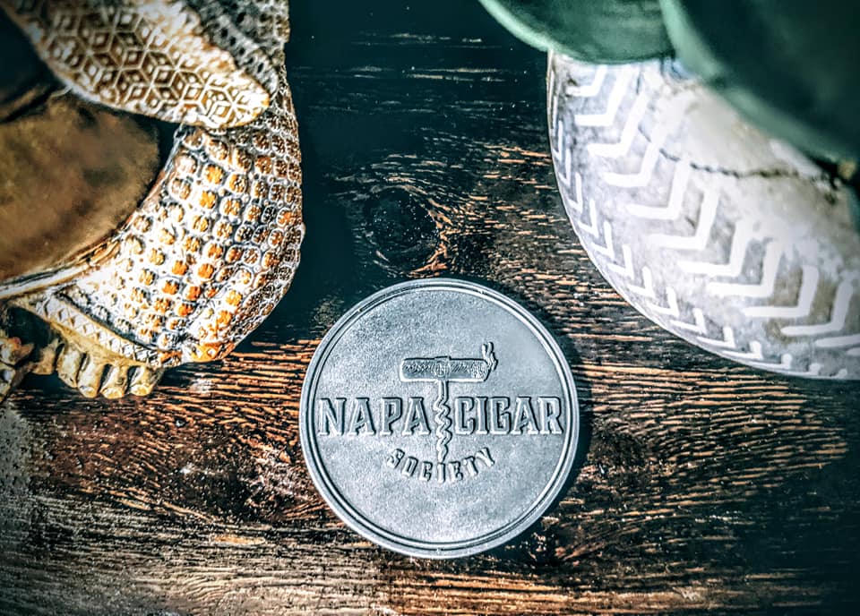 A silver custom challenge coin by Napa Cigar used for corporate branding